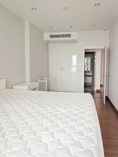 Spacious bedroom with modern design and ensuite bathroom in a contemporary apartment.