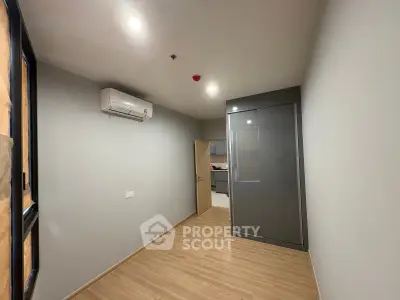 Modern unfurnished room with air conditioning and built-in wardrobe, featuring sleek wooden flooring.