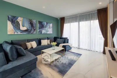 Modern living room with stylish blue decor and large windows for natural light.