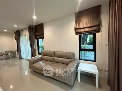 Modern living room with sleek leather sofa and elegant curtains