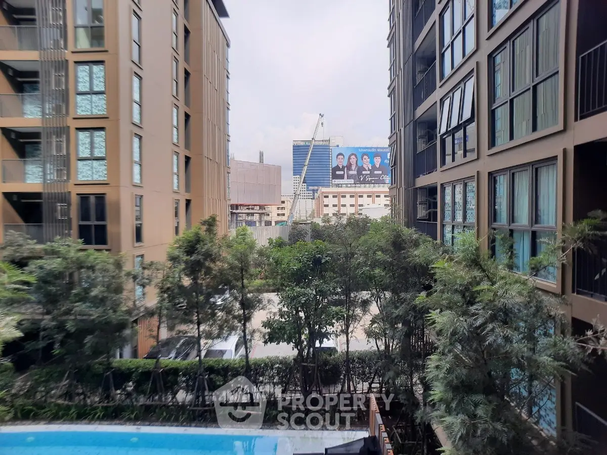 Modern apartment complex with pool and lush greenery, offering urban living with serene views.