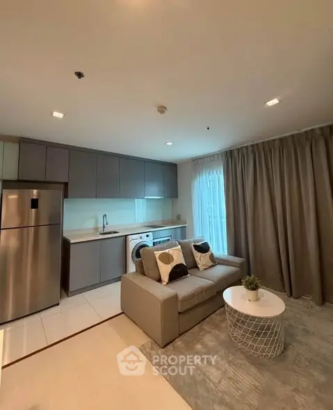Modern open-layout kitchen and living room with sleek design and cozy seating area.