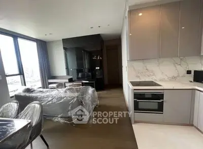 Modern open-plan kitchen and living area with sleek design and large windows.
