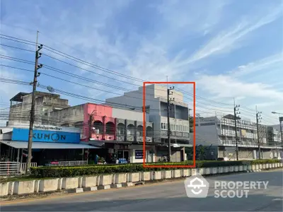 Commercial building exterior on a busy street with clear blue sky