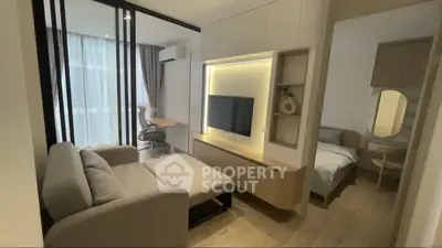 Modern living room with sleek furniture and cozy bedroom in open layout apartment.