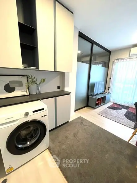 Modern apartment interior with washing machine and stylish living area.