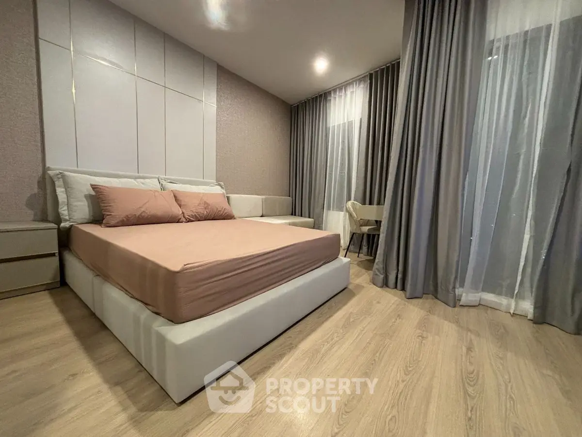 Modern bedroom with elegant decor and floor-to-ceiling curtains