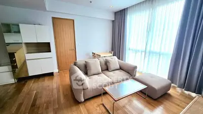 Spacious living room with modern furniture and large window for natural light.