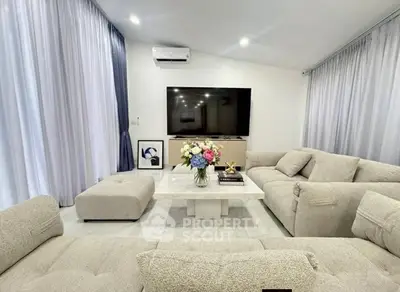 Luxurious living room with plush sofas and large TV, perfect for relaxation.