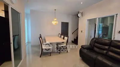 Elegant dining area with modern chandelier and cozy seating in a stylish home interior.