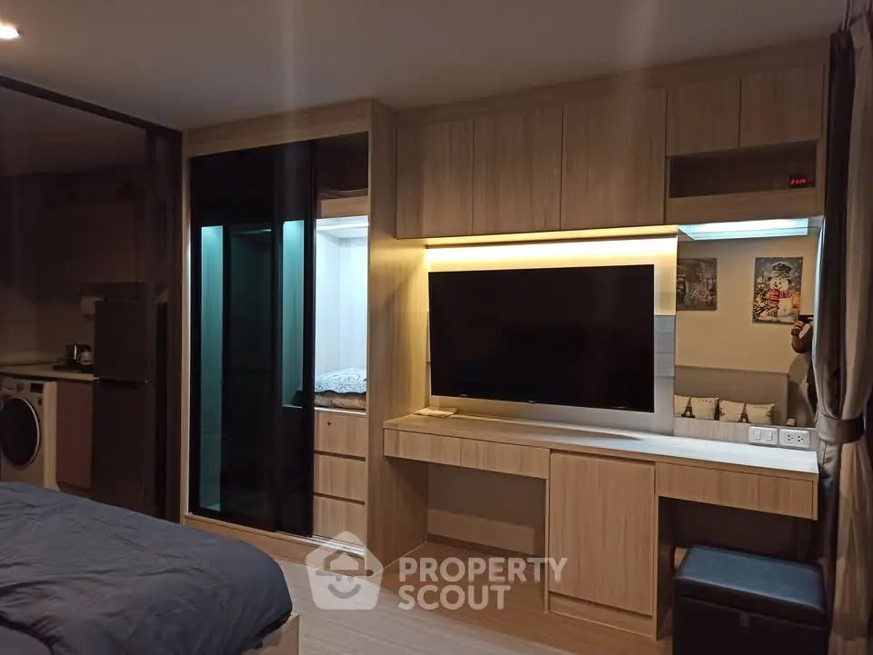 Modern bedroom with built-in wardrobe and entertainment unit, featuring sleek design and ambient lighting.
