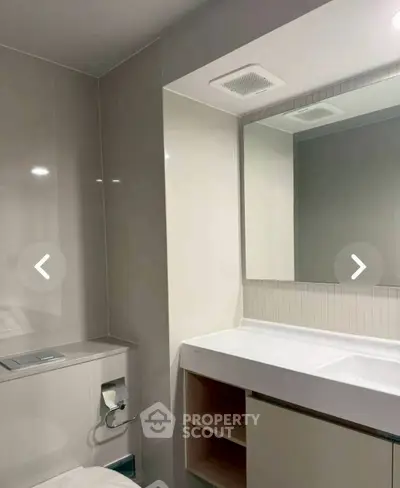 Modern bathroom with sleek design and large mirror in a contemporary apartment.