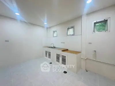 Spacious minimalist kitchen with white cabinetry and modern fixtures