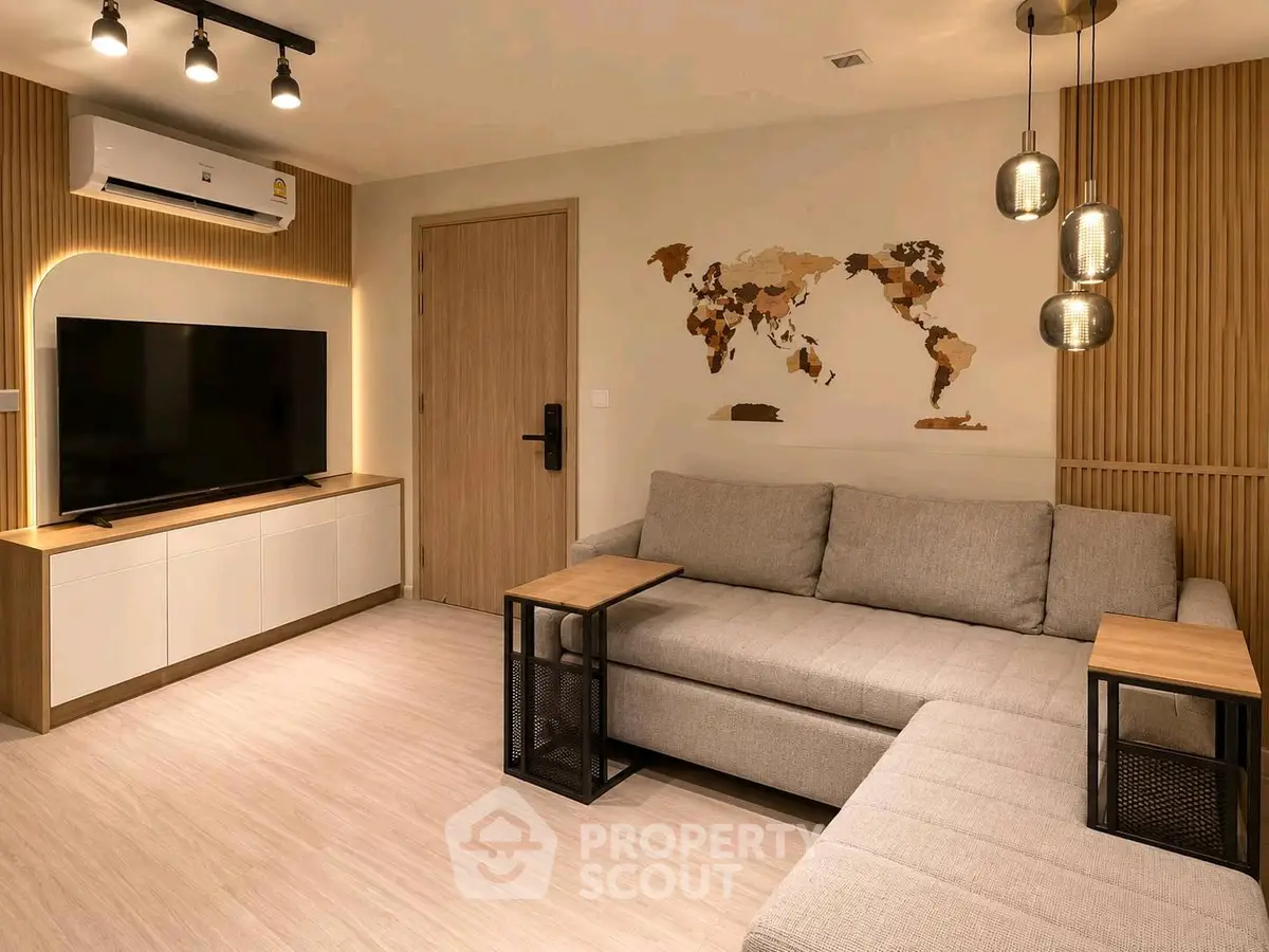 Modern living room with stylish decor and wall-mounted TV, featuring a cozy sectional sofa and ambient lighting.