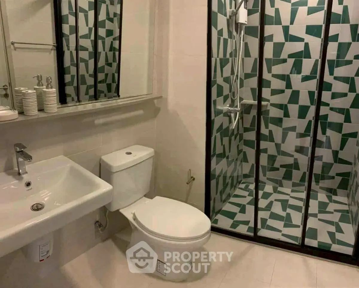 Modern bathroom with geometric shower tiles and sleek fixtures