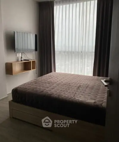 Modern bedroom with wall-mounted TV and large window with curtains