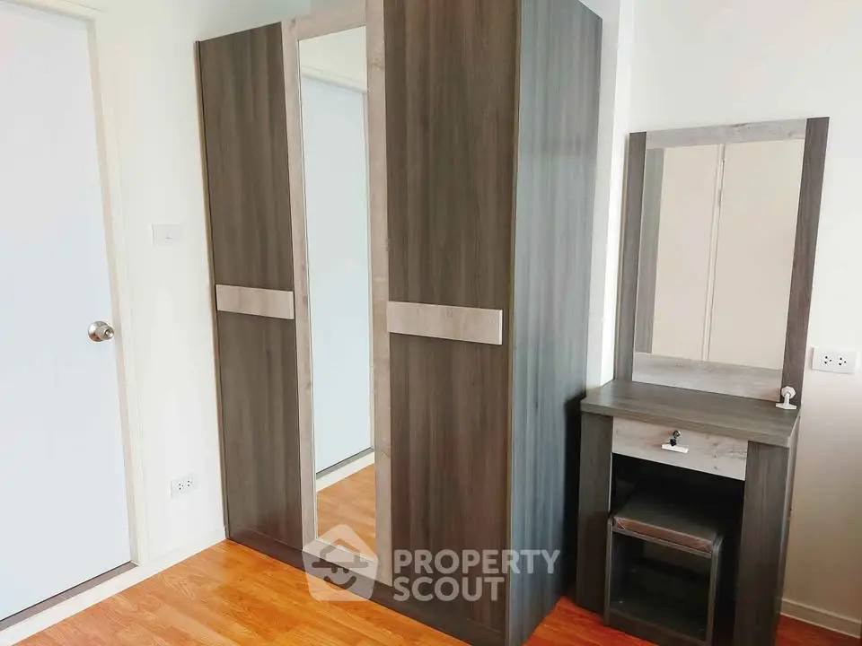Modern bedroom with stylish wardrobe and vanity set on wooden flooring.