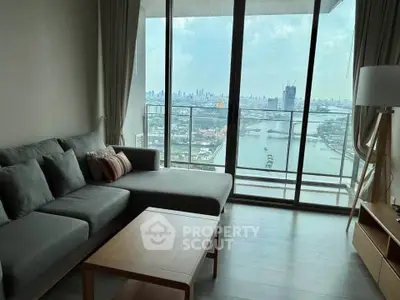 Spacious living room with stunning city and river view from large balcony.