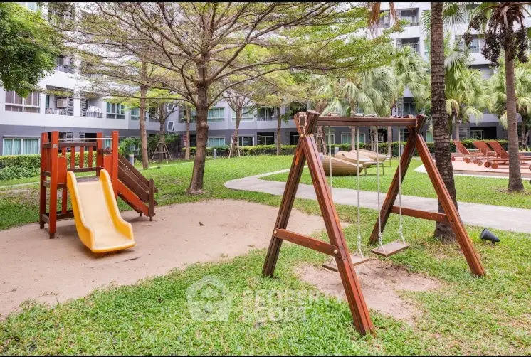 Charming residential playground with swings and slide in lush garden setting.