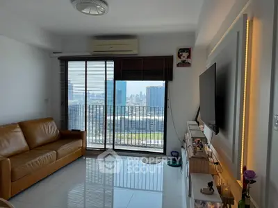 Modern living room with city view, leather sofa, and sleek TV setup.