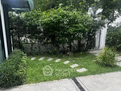 Charming garden view with lush greenery and stepping stones in a serene residential setting.
