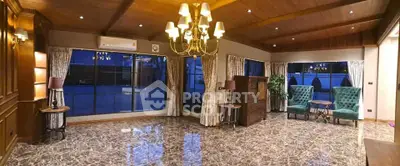 Luxurious living room with marble floors, elegant chandelier, and large windows offering a stunning view.