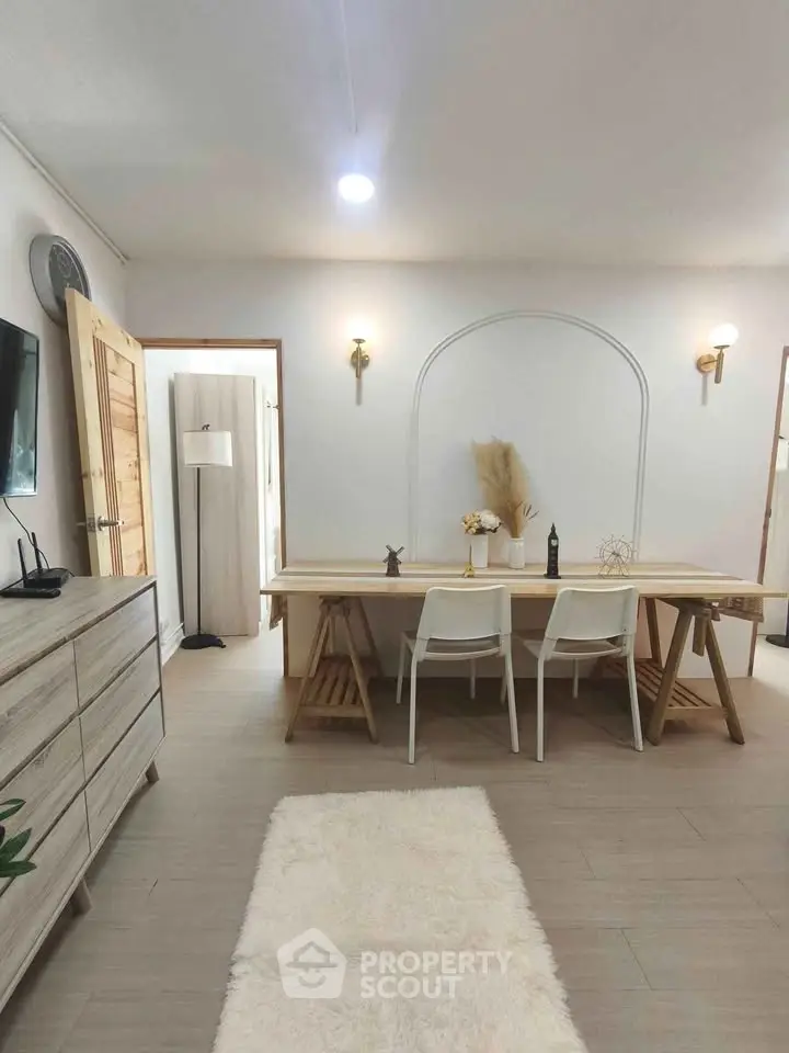 Modern dining area with minimalist decor and wooden furniture in a cozy apartment.