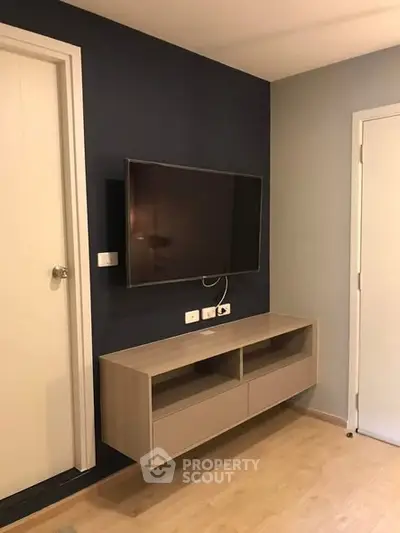 Modern living room with wall-mounted TV and sleek storage unit