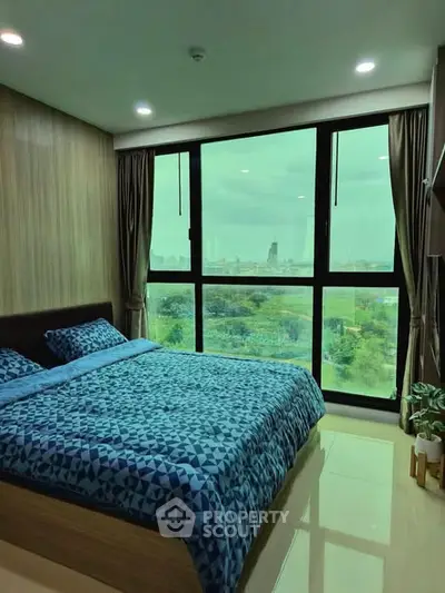Modern bedroom with large window offering stunning city view, featuring stylish decor and cozy bedding.
