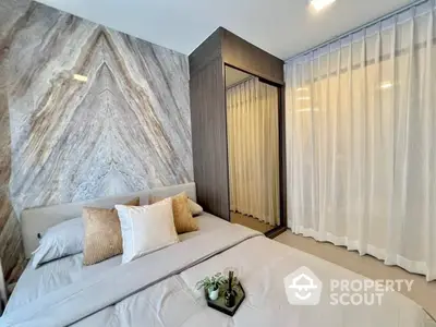 Elegant bedroom with a large bed, stylish marble accent wall, modern wardrobe, and floor-to-ceiling curtains offering a serene retreat.