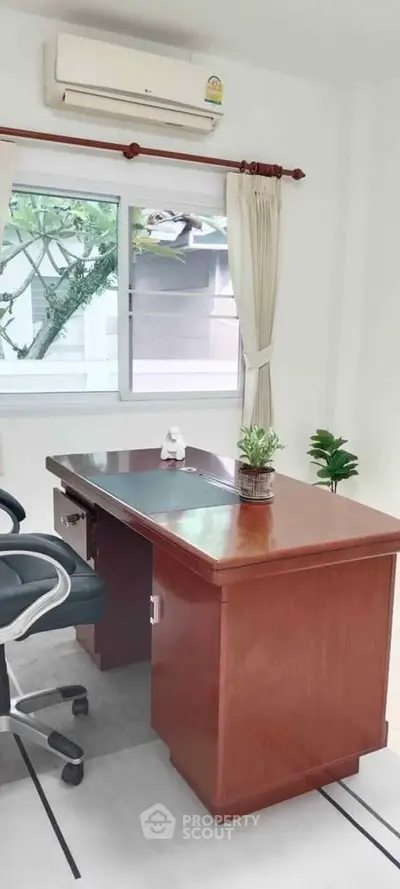 Bright study room with wooden desk and window view, ideal for productivity.