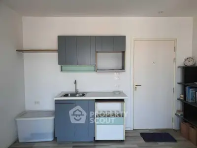 Compact kitchen with modern cabinetry and sleek design in a cozy apartment.