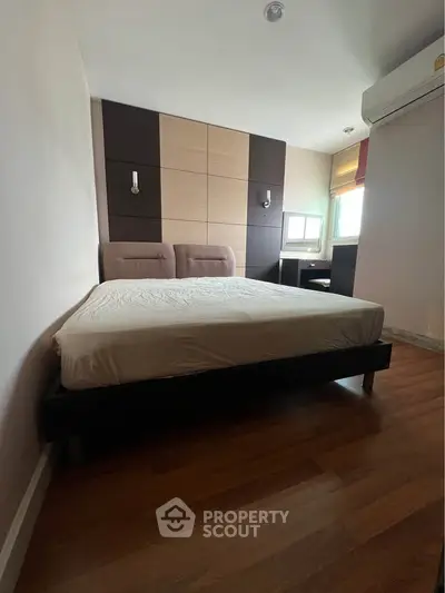 Modern bedroom with stylish decor and natural light, featuring a comfortable bed and wooden flooring.