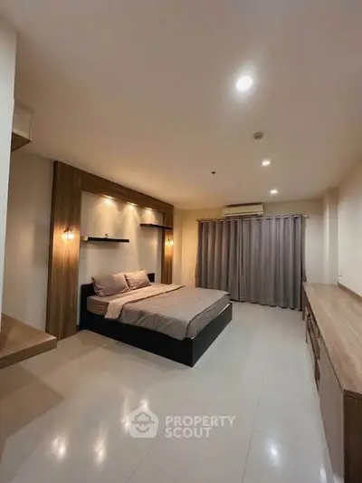 Spacious modern bedroom with elegant lighting and sleek furnishings