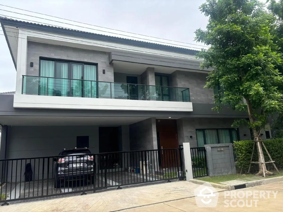 Modern two-story house with spacious balcony and garage in a serene neighborhood.