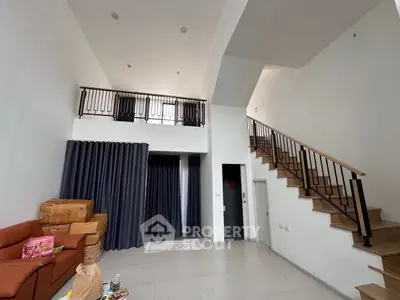 Spacious modern living room with high ceiling and mezzanine level