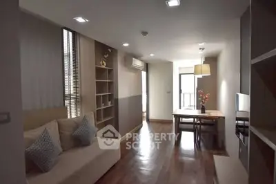 Modern living room with cozy seating and dining area, featuring stylish decor and ample natural light.