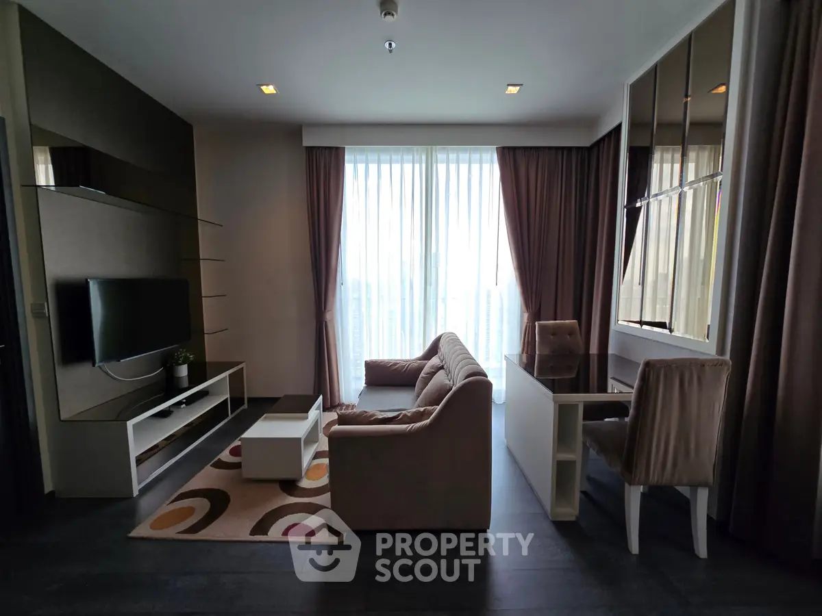 Modern living room with stylish furniture and large window offering natural light.