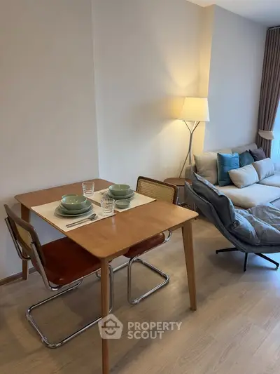 Modern living room with cozy seating and dining area, featuring stylish decor and warm lighting.