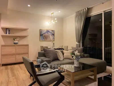 Modern living room with elegant decor, featuring a cozy sofa, stylish armchair, and chic dining area.