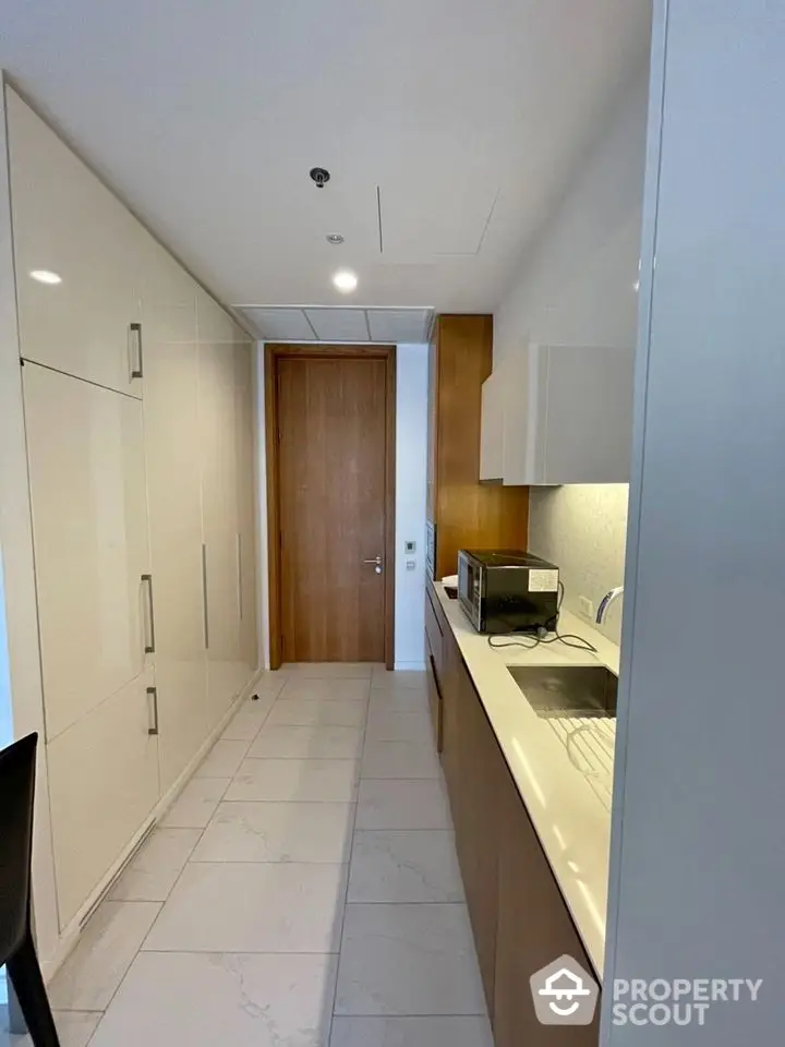 Modern kitchen with sleek cabinetry and built-in appliances in a compact layout.