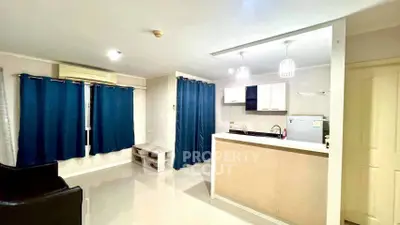 Modern open-layout living room with stylish kitchen and blue curtains