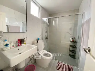Modern bathroom with glass shower and sleek fixtures in a bright, airy space.