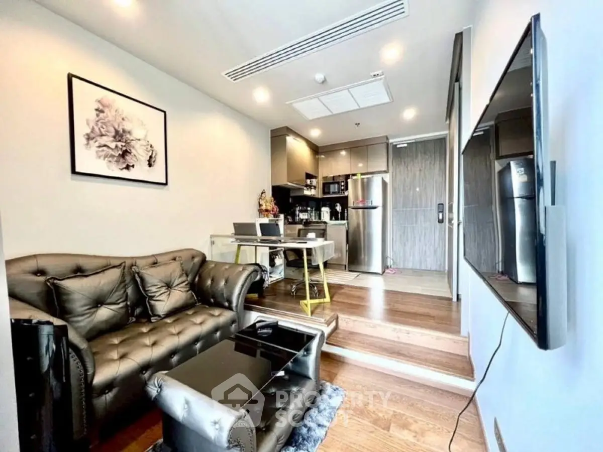 Modern living room with stylish decor and open kitchen layout, featuring sleek furniture and contemporary design.