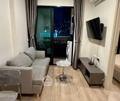 Modern living room with city view, featuring cozy sofa and wall-mounted TV.