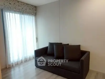 Cozy living room with modern sofa and large window with sheer curtains