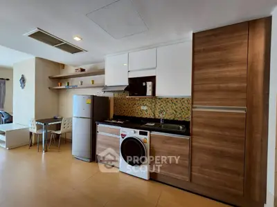 Modern kitchen with wooden cabinets, stainless steel appliances, and a cozy dining area.
