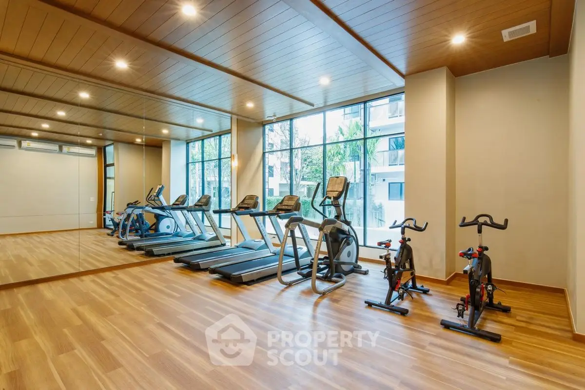 Modern gym with treadmills and exercise bikes in a luxury apartment building.