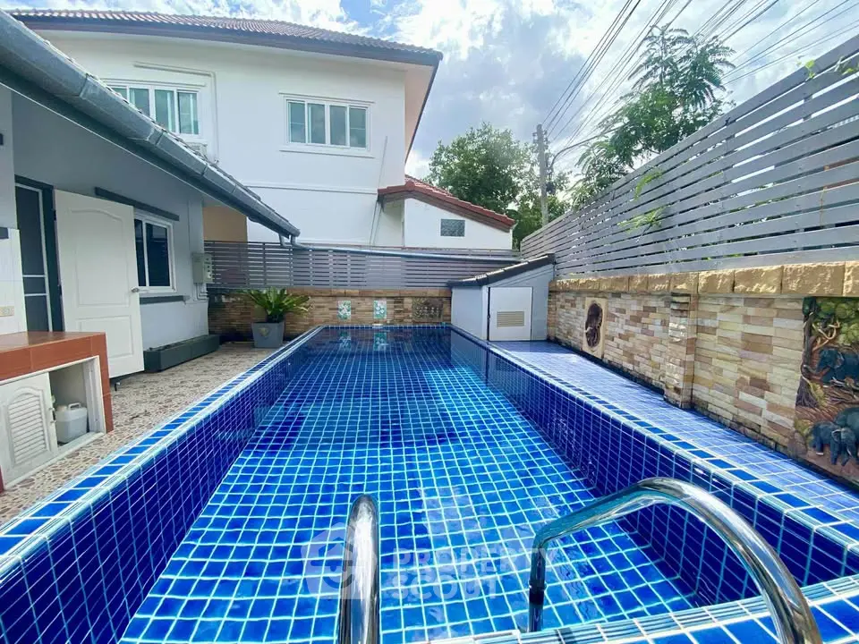 Charming residential property with a stunning blue-tiled swimming pool and modern exterior design.