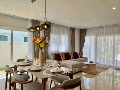 Elegant living room with dining area, modern decor, and ample natural light.